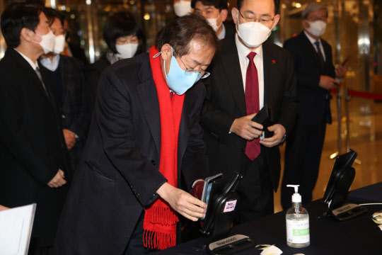 지난 3일 홍준표(가운데) 국민의힘 의원이 대구 북구 인터불고 호텔에서 열린 대구경북 신년교례회에서 참석해 QR코드를 찍고 있다. 연합뉴스.